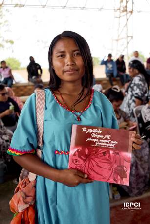 Joven wayuu sostiene una cartilla sobre el legado de la mujer Wayúu