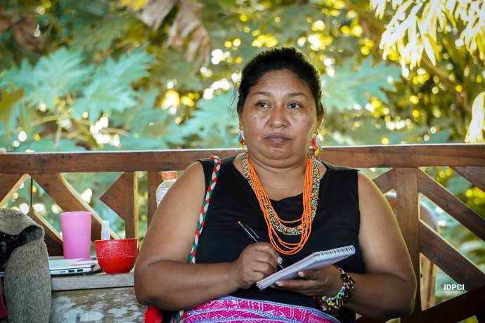 Lideresa toma apuntes con collares tradicionales de chaquiras