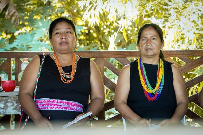 Dos lideresas con collares de chaquiras durante una sesión