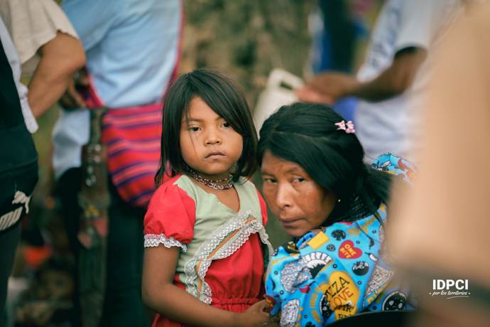 Niña junto a su madre en un encuentro comunitario